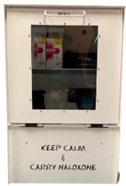 A view of the front of the overdose prevention box. It has text on the front that says, "KEEP CALM &amp; CARRY NALOXONE".