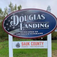 American Flag on background of Douglas Landing sign, Dedicated to American's Veterans