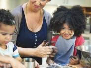 woman and two children working together baking