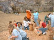  A group of students and adult volunteers mix and bag prairie seeds for planting.