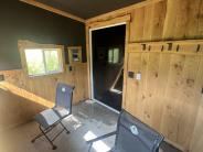 Inside of the blind showing two chairs and windows looking out over green grass