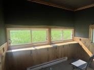 Inside of the blind showing two chairs and windows looking out over green grass