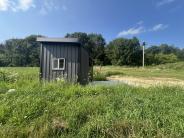 Accessible hunting blind with green grass, woods and sky 