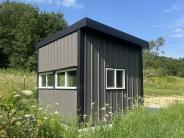 Accessible hunting blind with green grass, woods and sky 