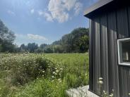 Accessible hunting blind with green grass, woods and sky 