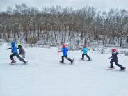 Five kids racing in their snowshoes