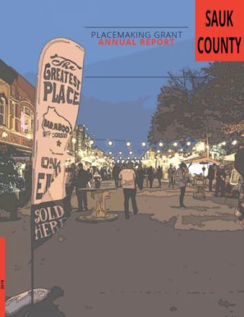 Downtown Baraboo street lit by string lights, crowd in background along shops.