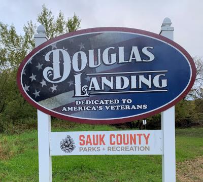 American Flag on background of Douglas Landing sign, Dedicated to American's Veterans