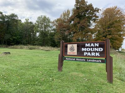 Sign at Man Mound with effigy mound in background