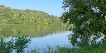 Office closed April 3, image shows lake with trees surrounding it on a sunny day