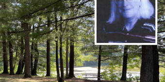 Tall pines trees in front of a body of water with a picnic table underneath, and a photo of John Paul Mueller on top